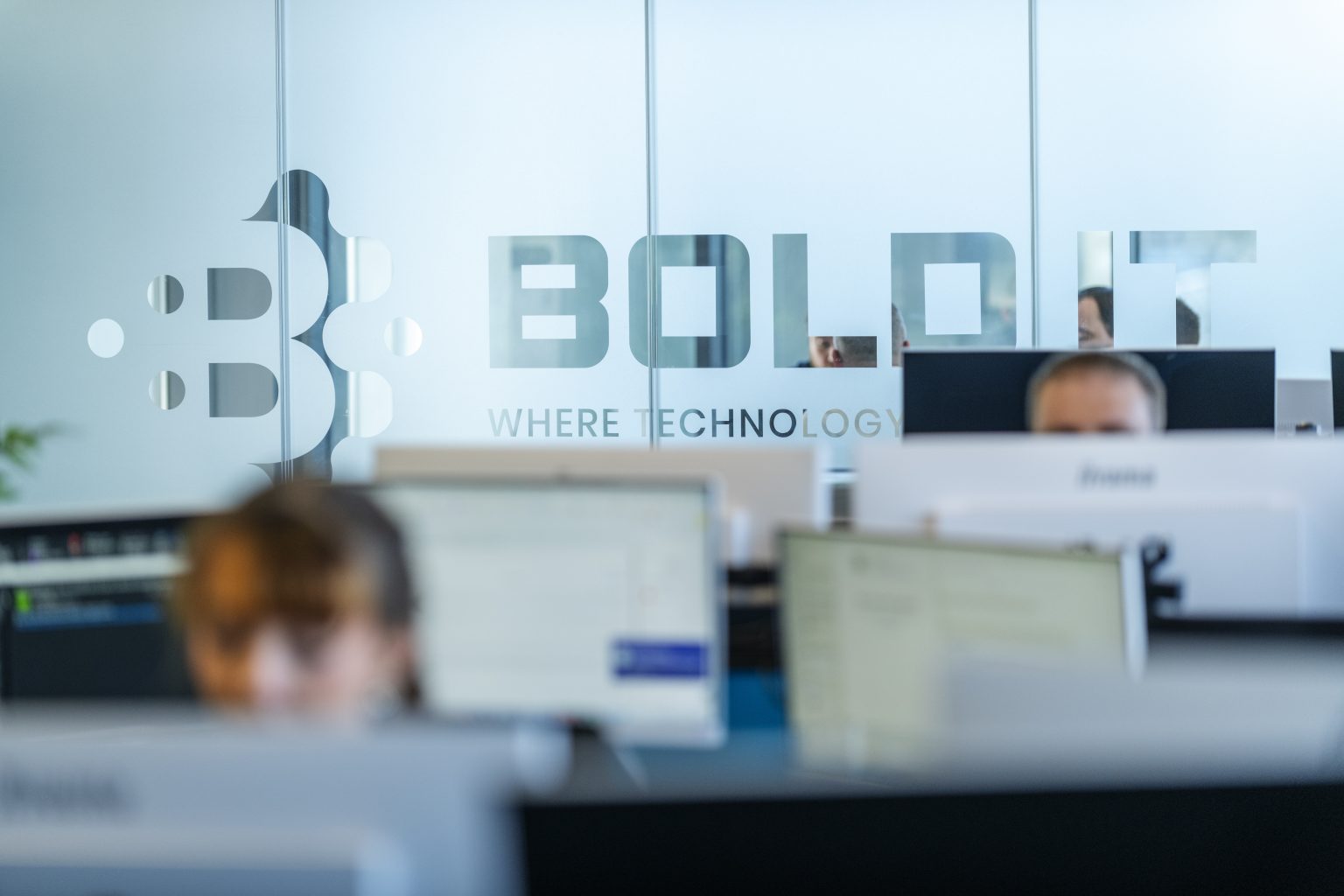 The Bold IT team at work behind the branded glass in their office